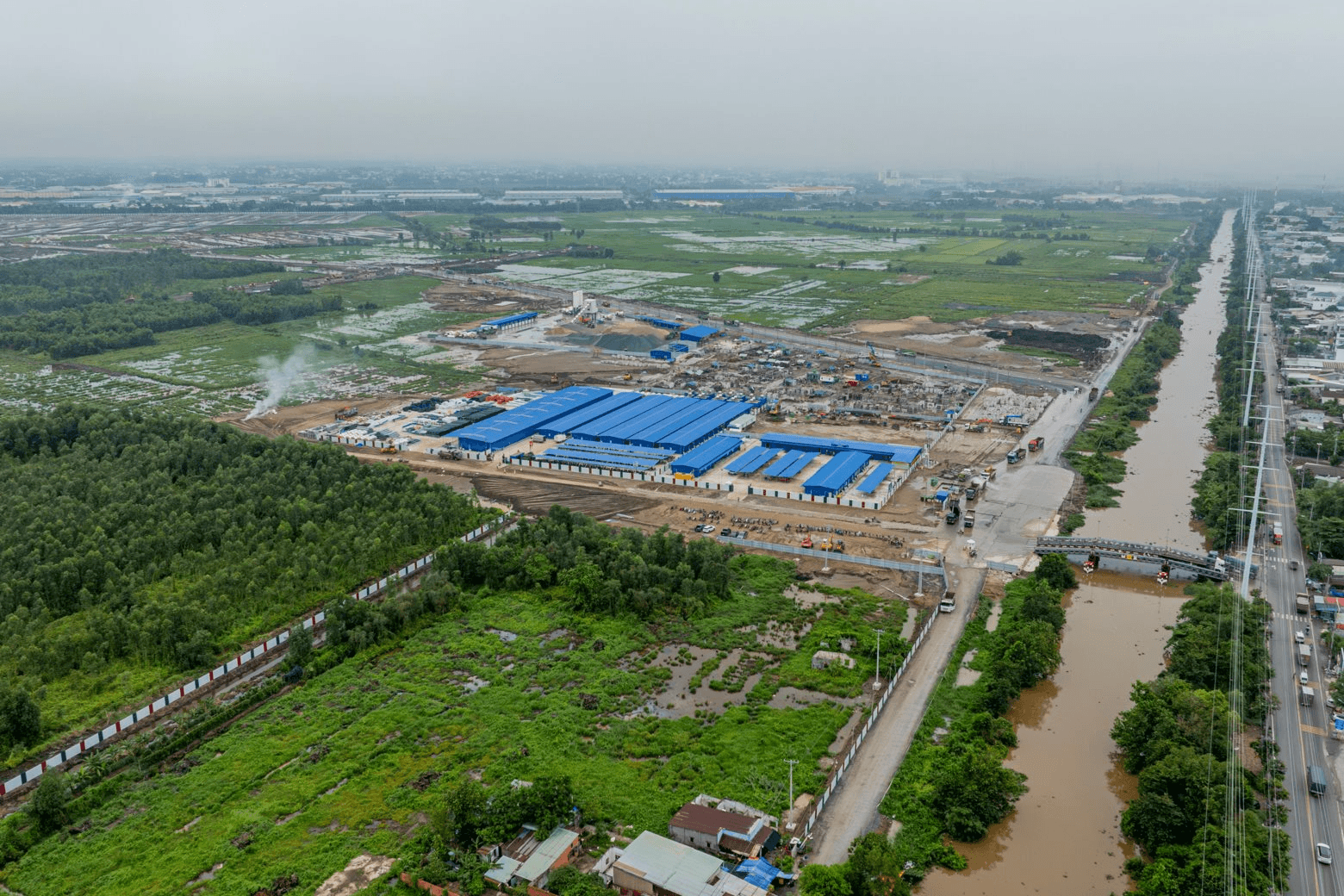 Công trường thi công Vinhomes Hóc Môn nhìn từ trên cao, gần kênh rạch và tuyến đường vận chuyển